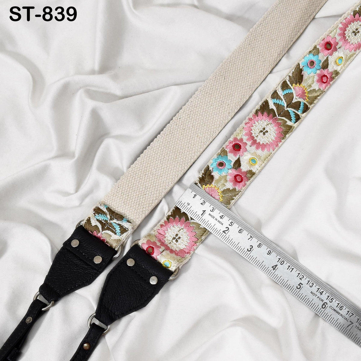 a beige strap with a floral pattern, placed on a white fabric surface. A ruler is placed next to the strap, indicating its size.