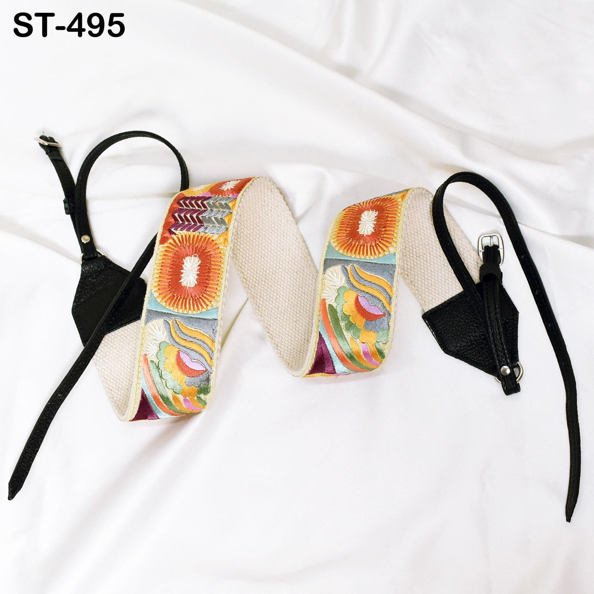a pair of colorful, patterned straps or belts laid out on a white surface.