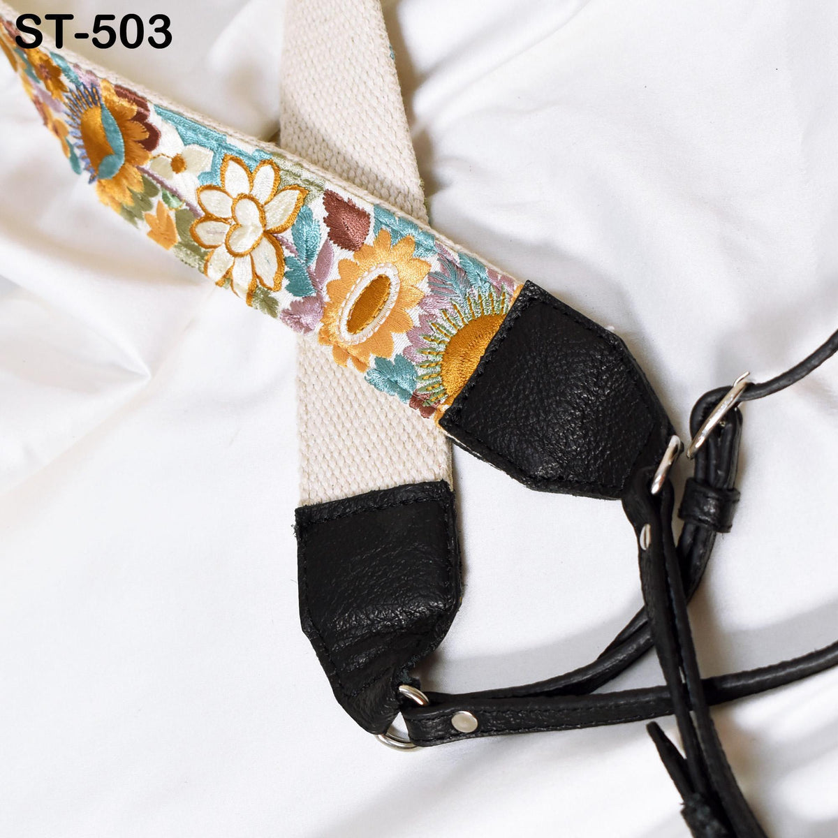 A colorful strap with a floral pattern, attached to a black leather strap, is shown in the image.