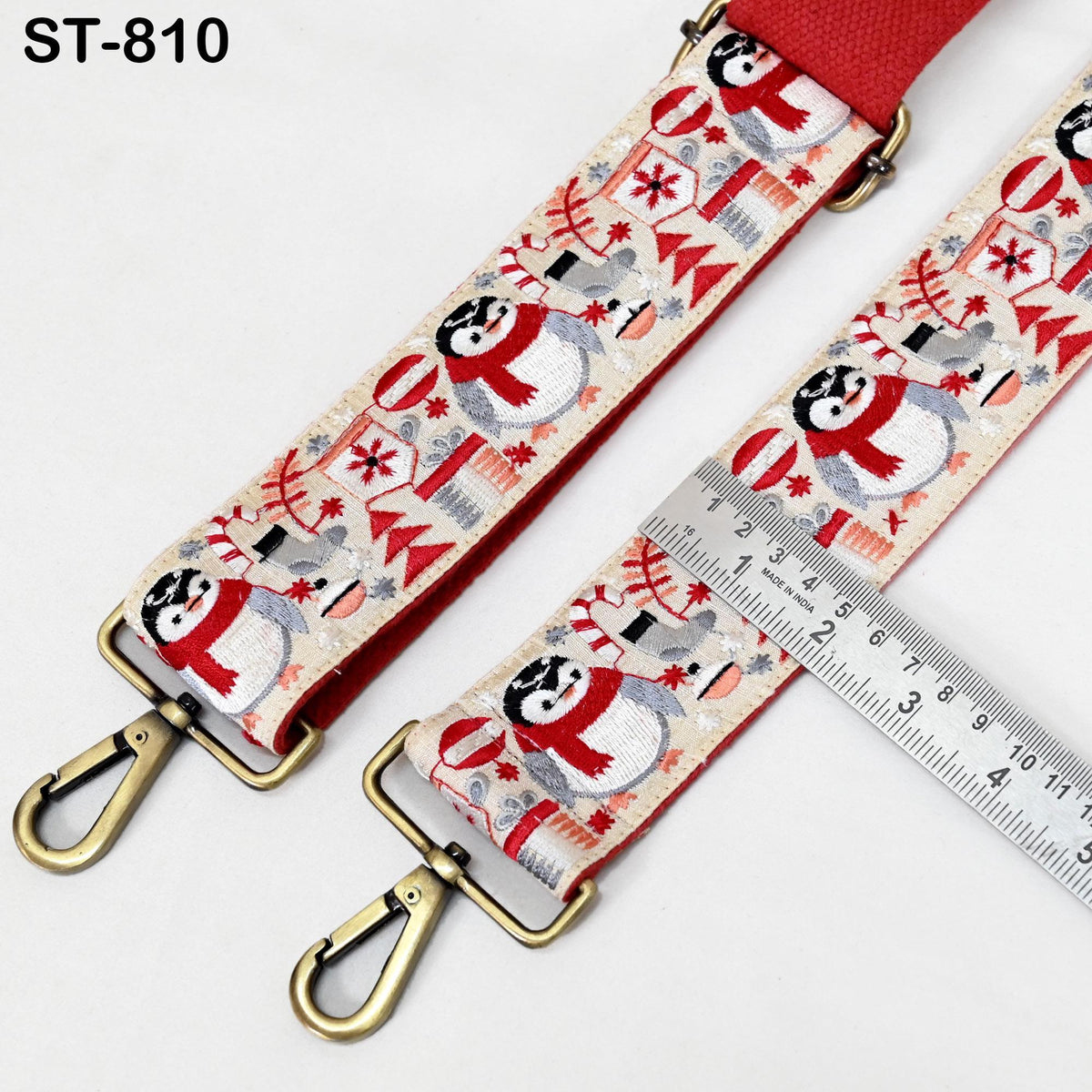 A red and white patterned strap with a metal ruler placed on it, indicating the strap's size.