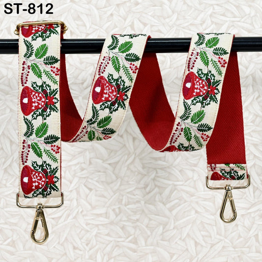 A red and white patterned fabric strap with a metal clasp and hook attached to a black metal bar.