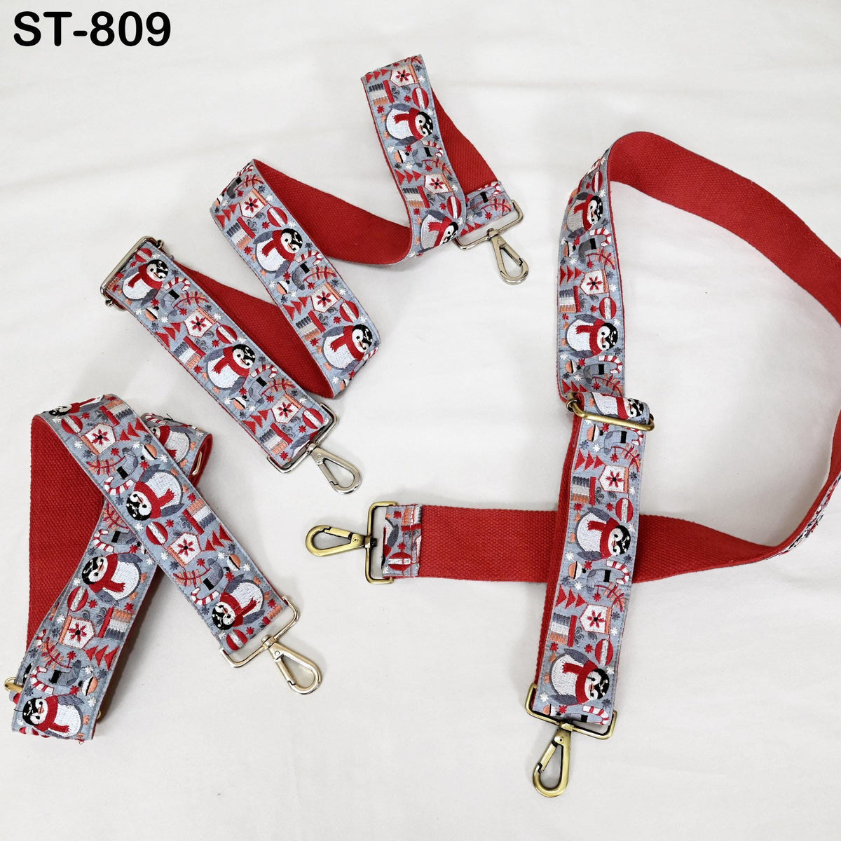 A set of red and gray patterned straps with metal hooks, arranged on a white background.