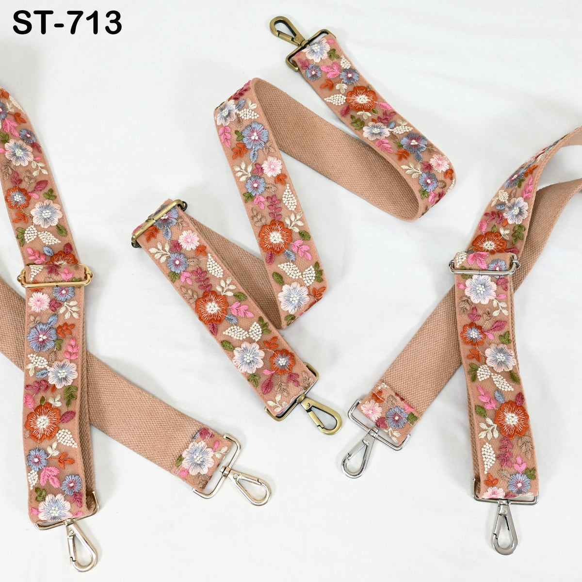 a collection of beige floral straps with metal hooks, arranged on a white background.