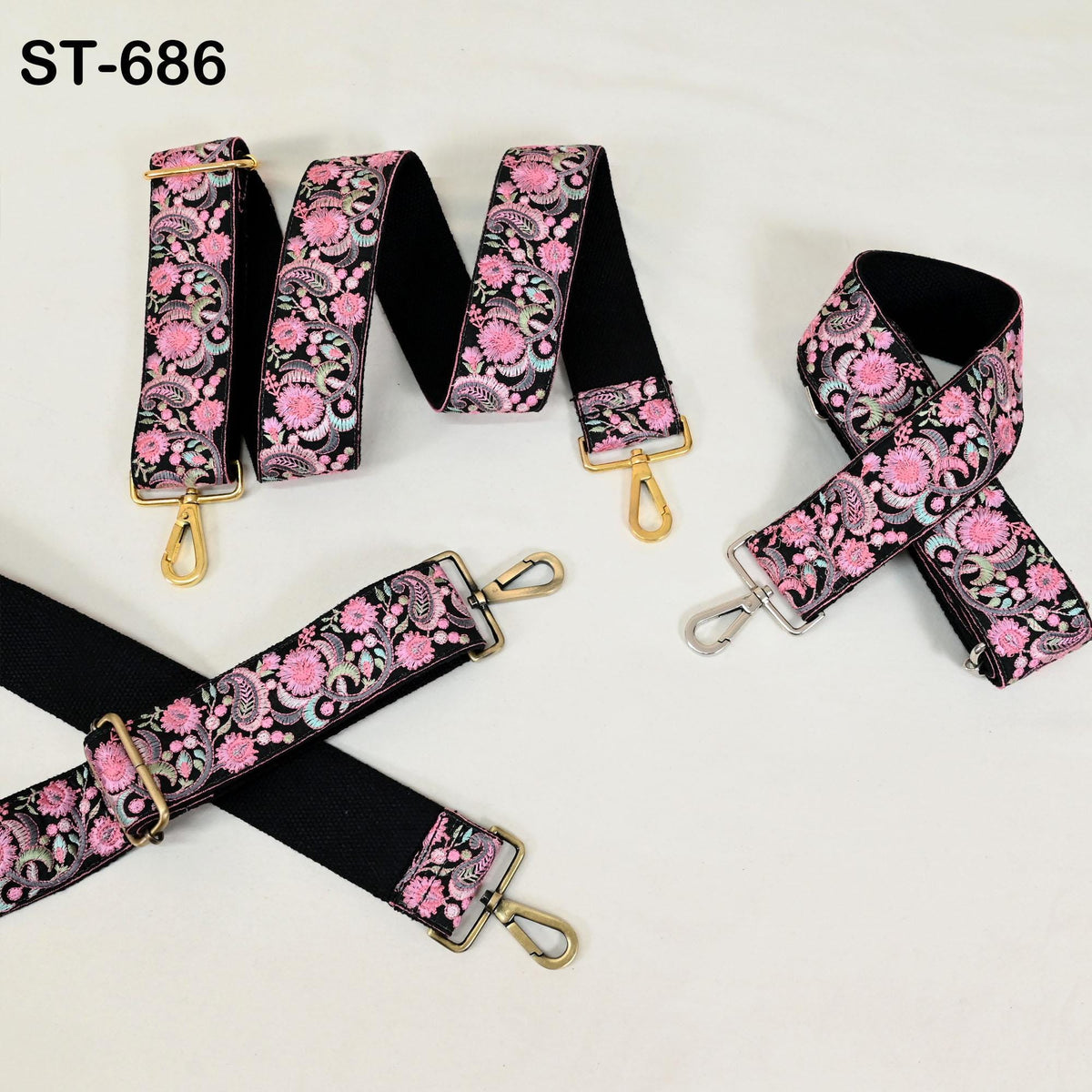 a collection of colorful straps with floral patterns, including black straps with gold buckles and pink straps with gold buckles.