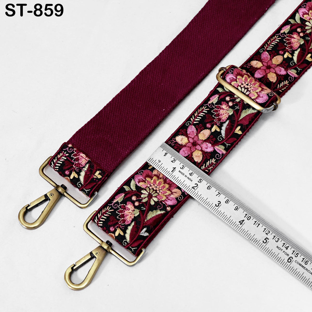 a burgundy-colored strap with a floral pattern, and a ruler is placed next to it, indicating the strap's length.