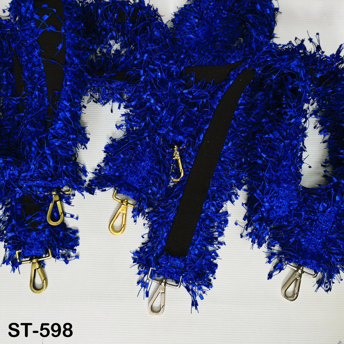 a close-up view of a blue, fuzzy fabric with gold hardware attached to it.