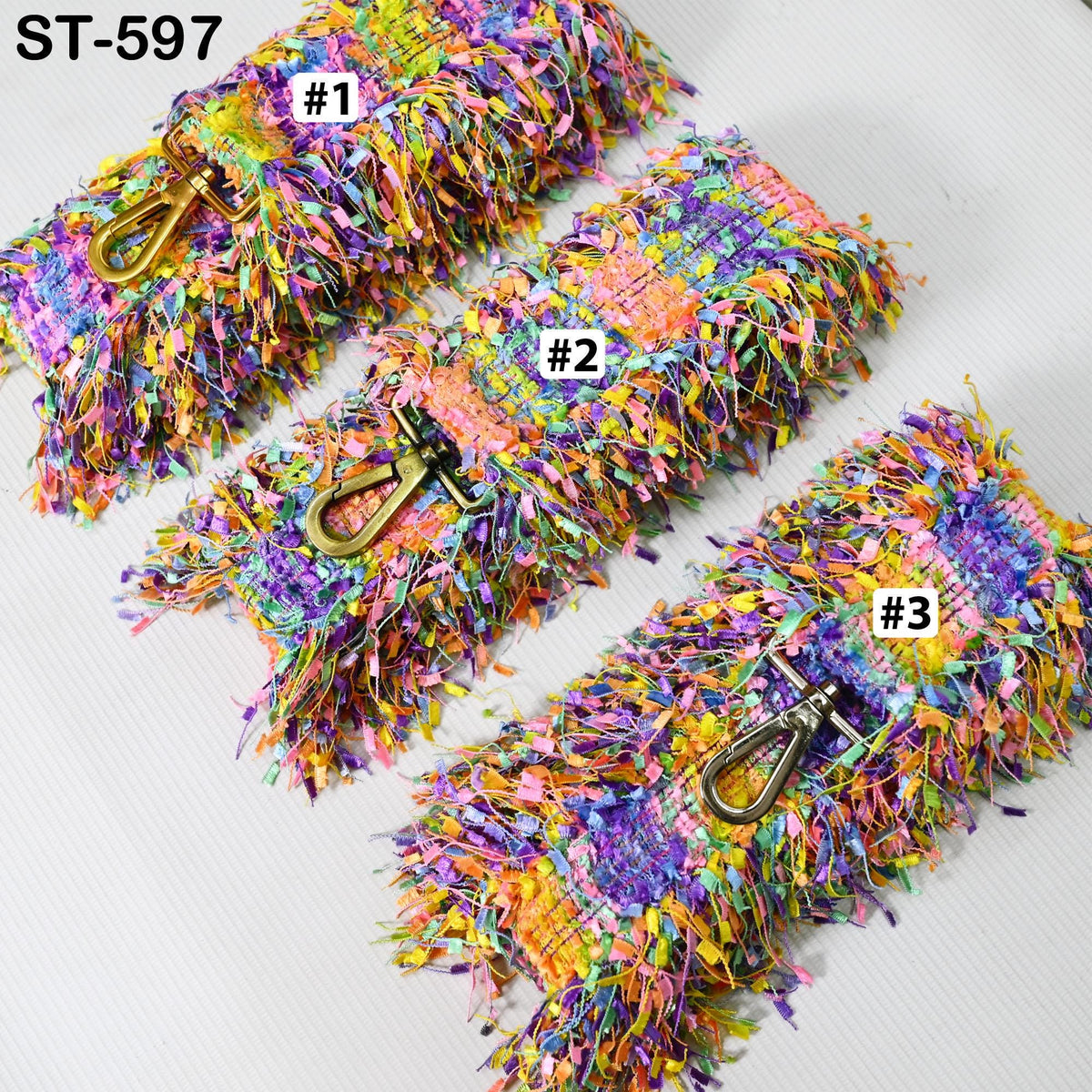 a collection of colorful, textured fabric items with metallic buckles, arranged in a row.