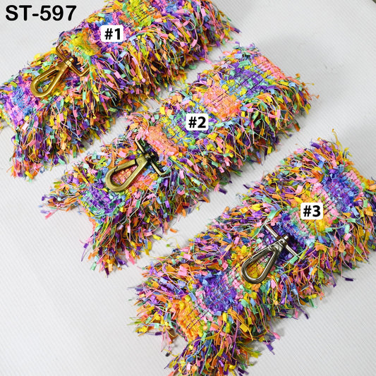a collection of colorful, textured fabric items with metallic buckles, arranged in a row.