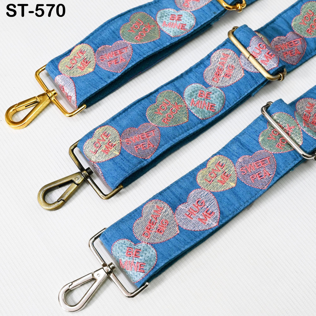 a collection of three blue straps with heart-shaped embroidered phrases on them.