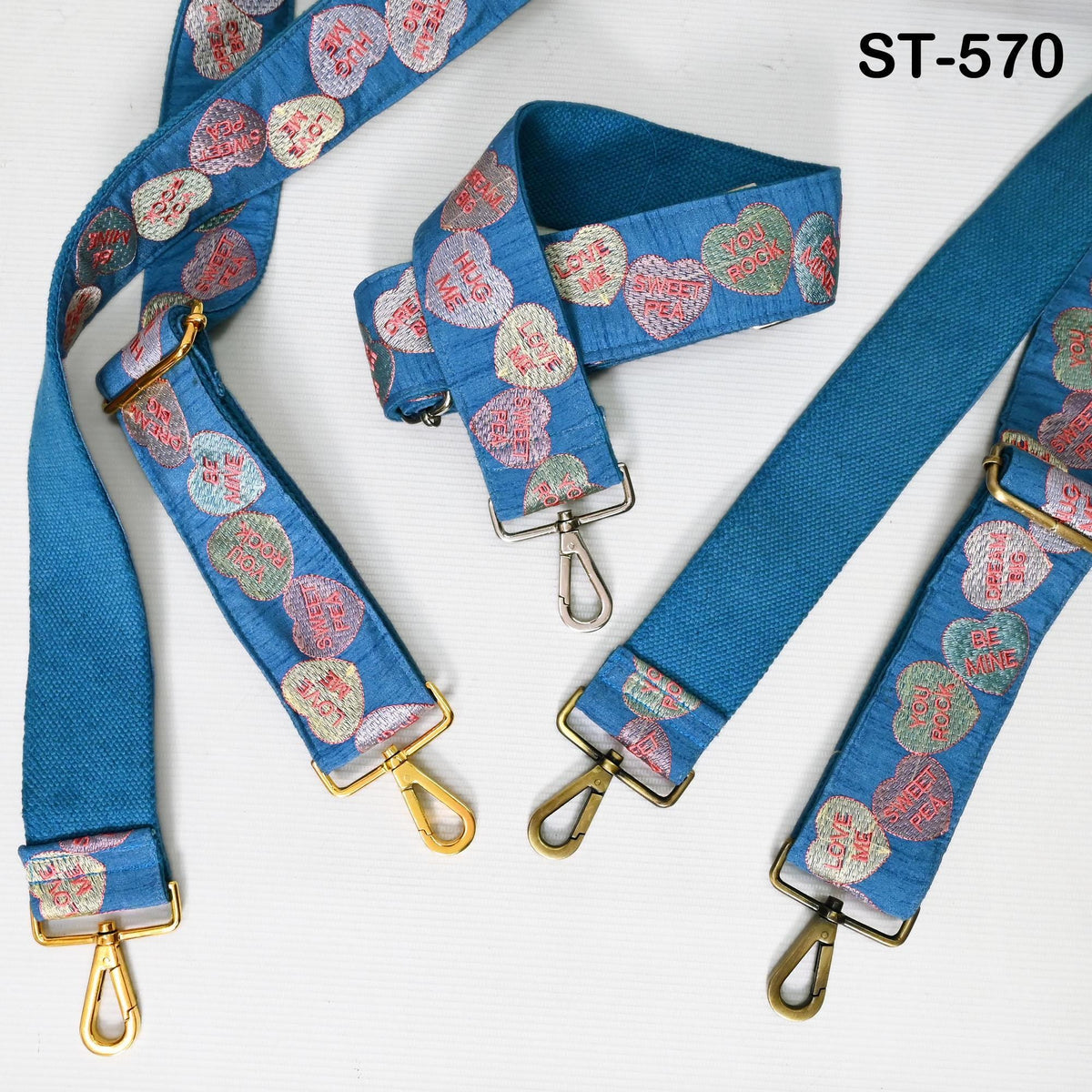 a collection of blue straps with heart-shaped embroidery patterns, arranged on a white background.