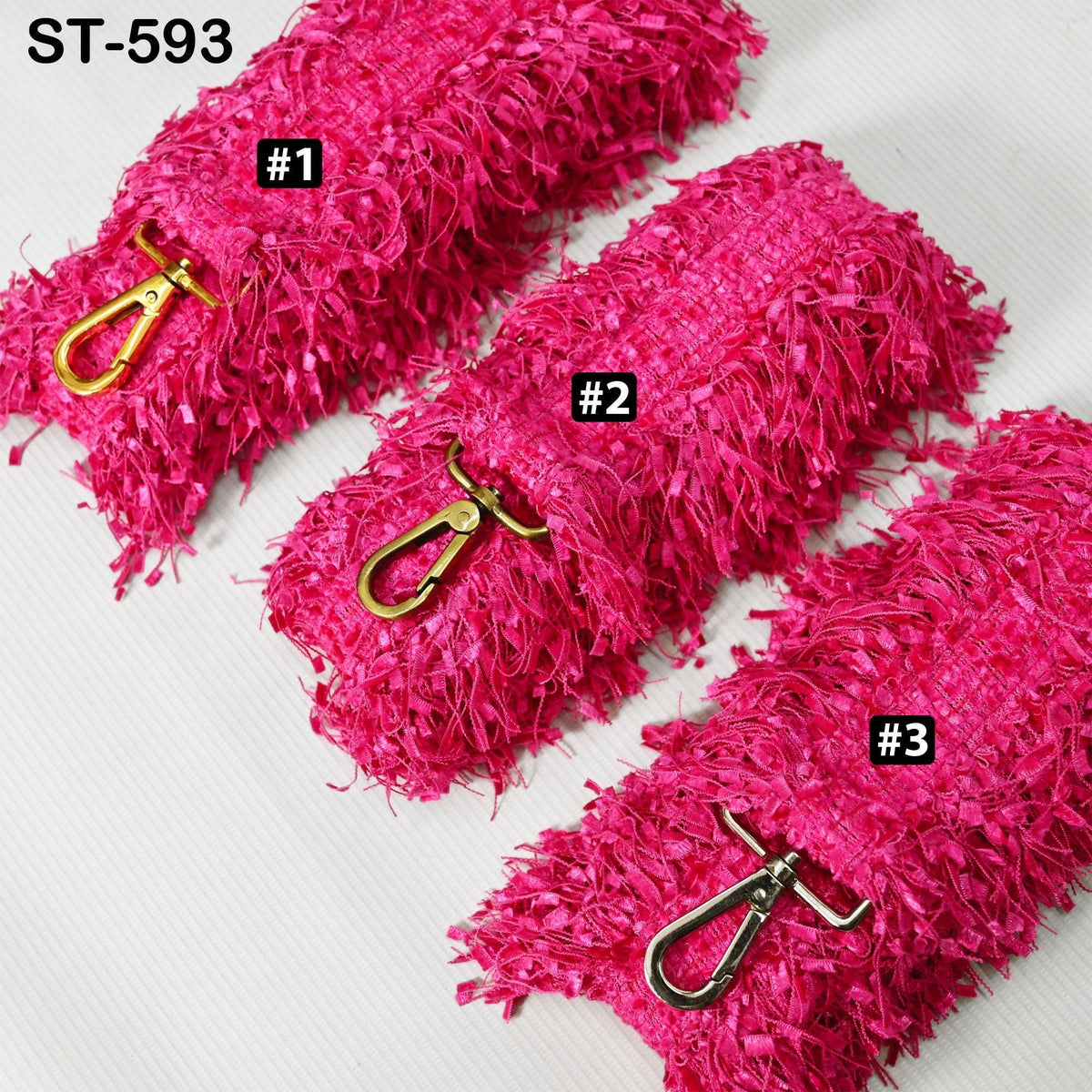three pink fuzzy straps with metal hooks, each with a different number printed on it.