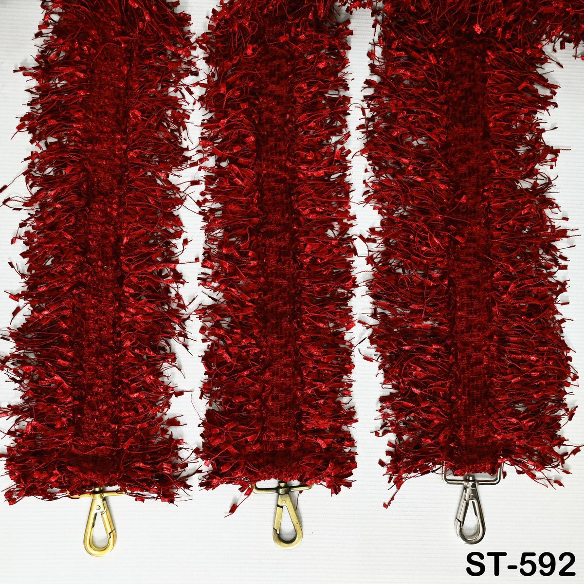 Three red tinsel strands arranged in a row, each with a gold hook at the bottom.