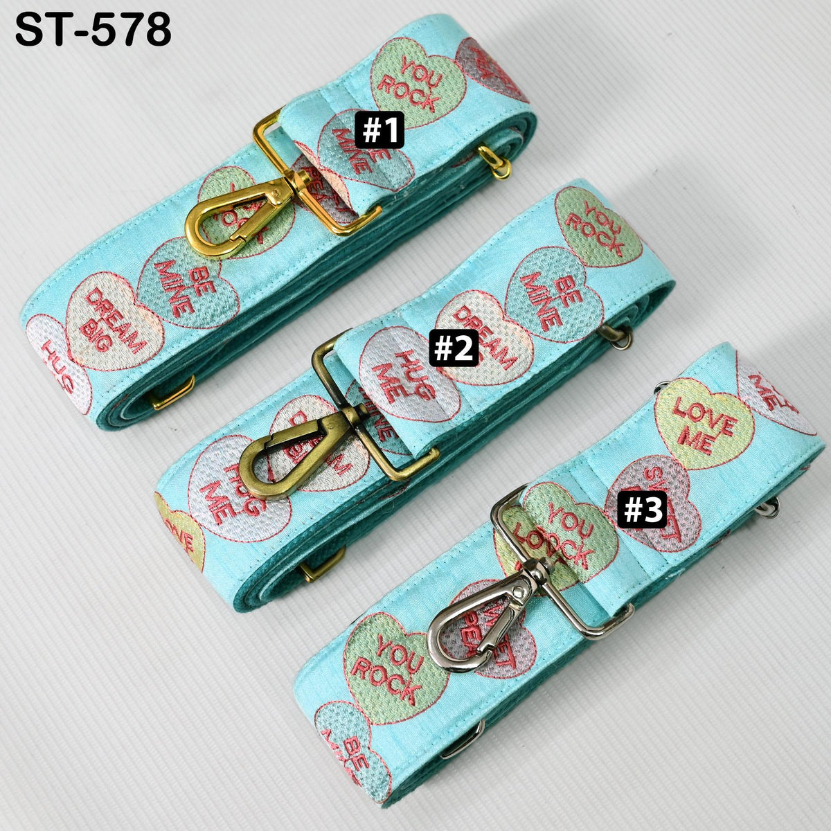 three heart-shaped straps with different designs and text on them.