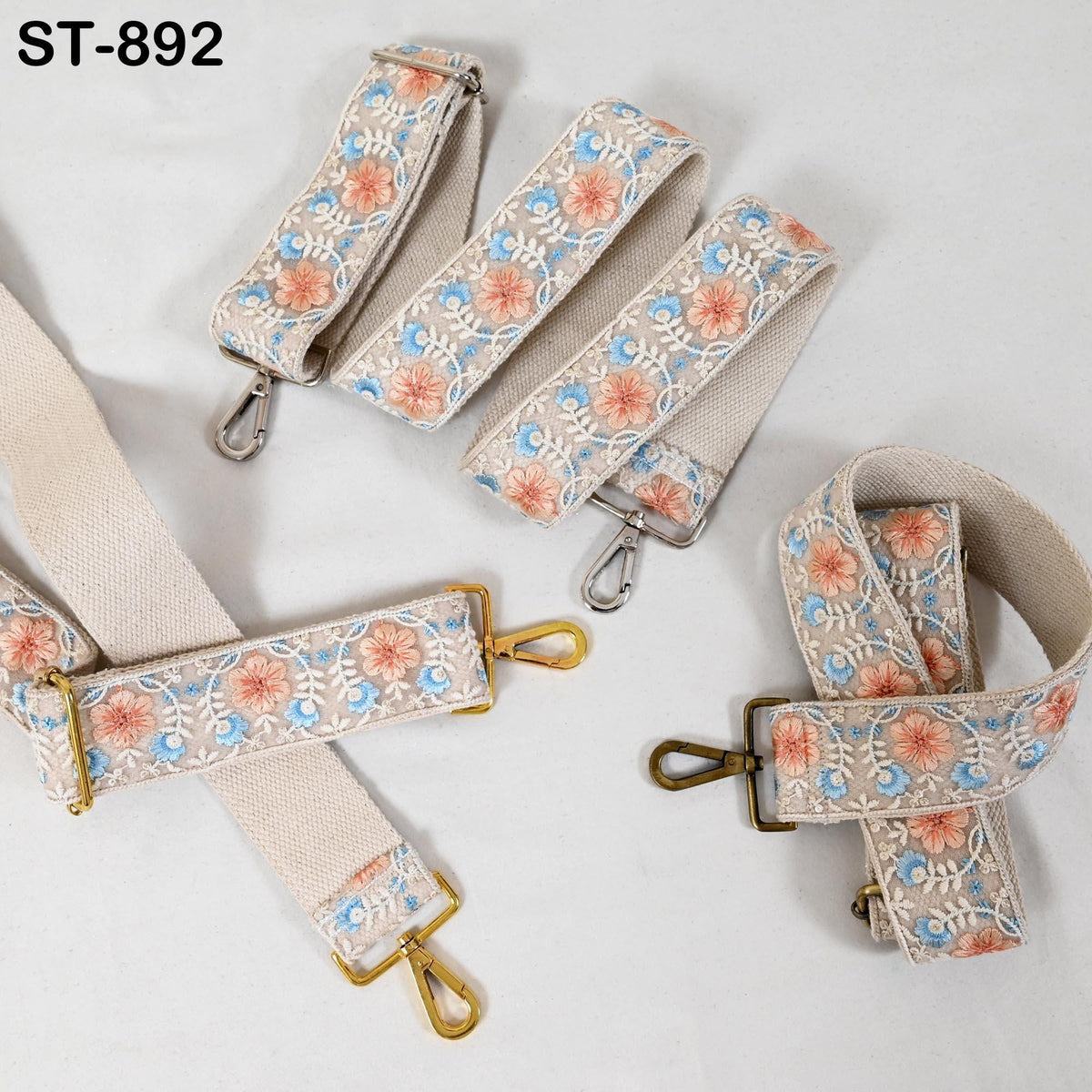 a collection of beige and floral-patterned straps with metal buckles, arranged on a white background.