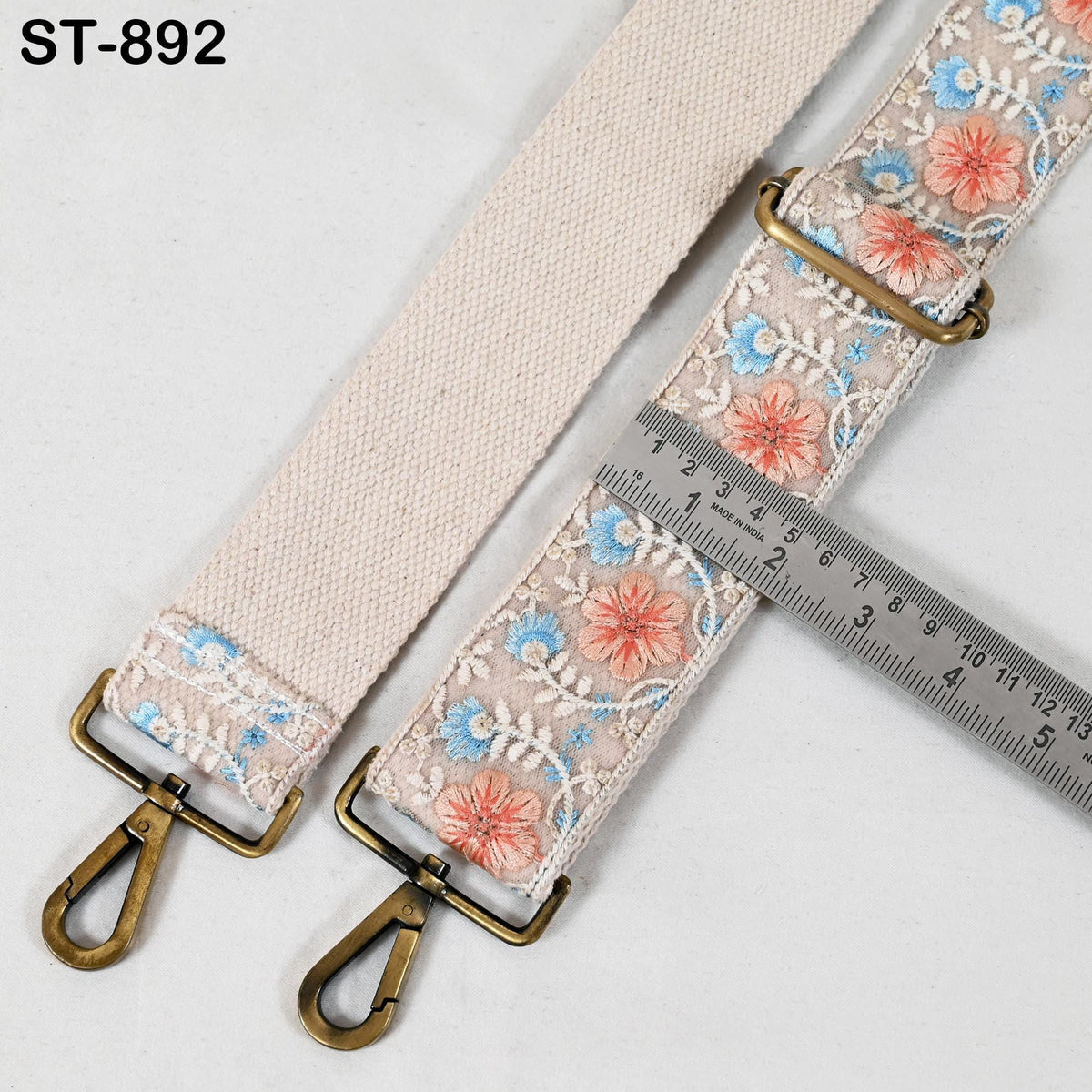 a beige strap with a floral pattern, featuring a metal clasp and a metal ruler for size comparison.