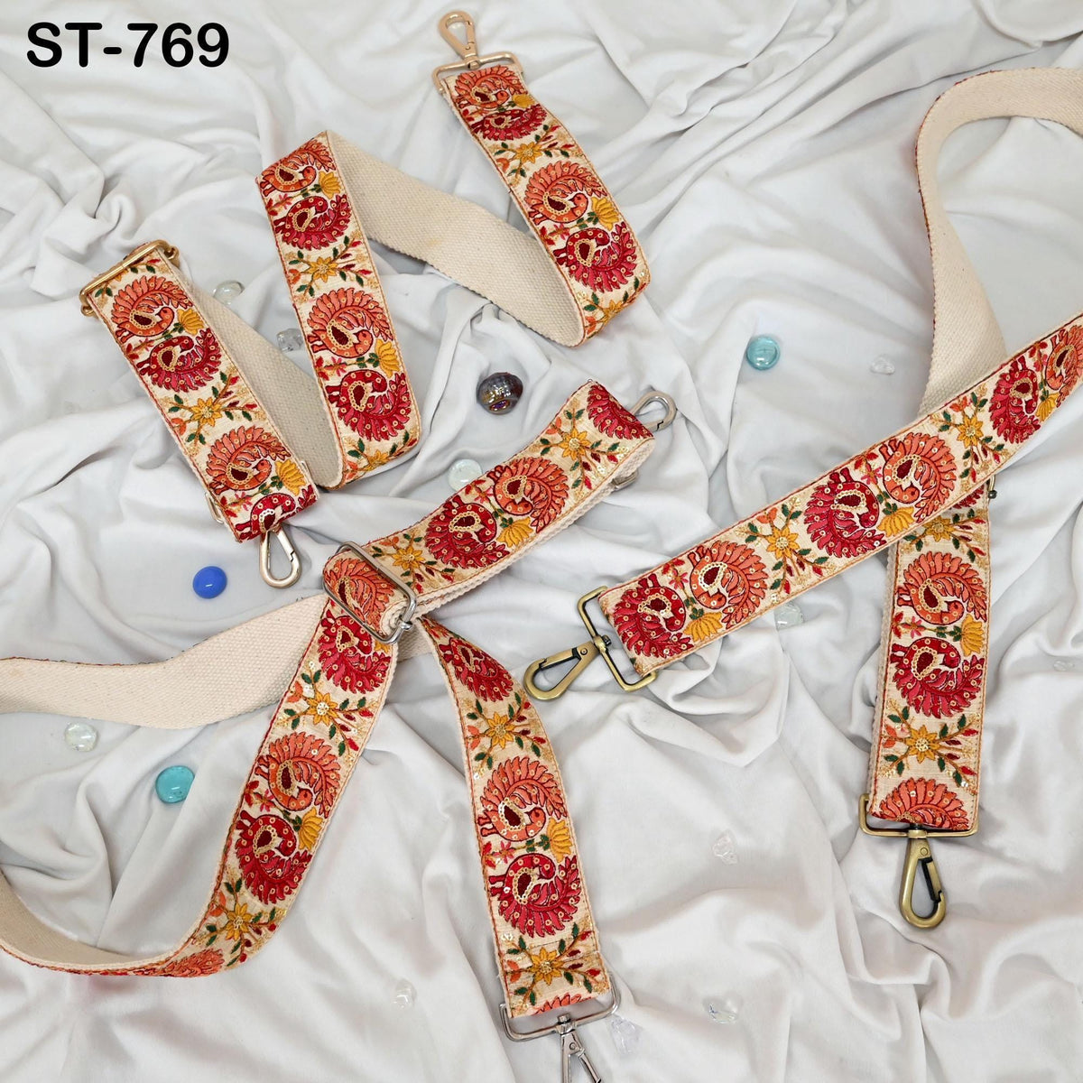 a collection of colorful, patterned straps and buckles arranged on a white cloth background.