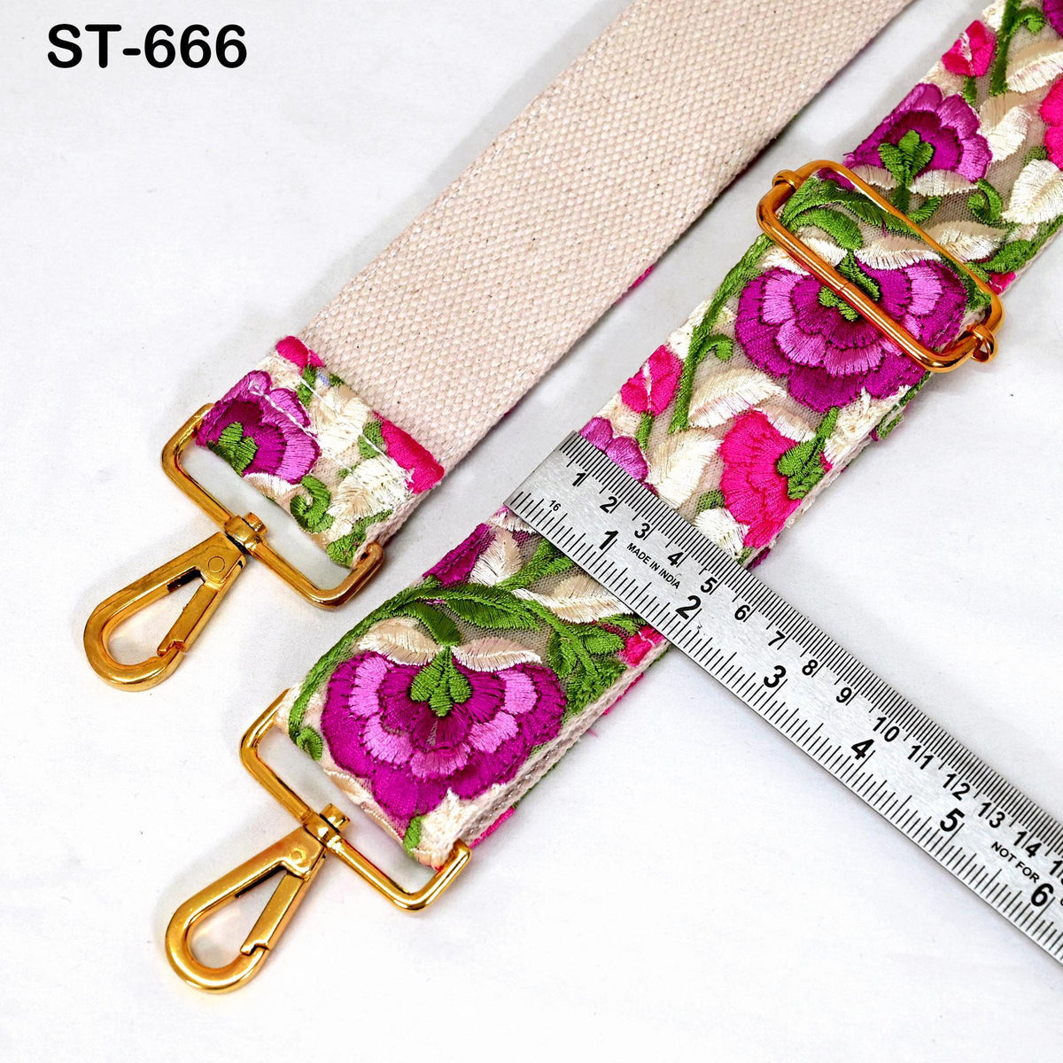 a strap with a floral pattern and a ruler placed next to it, indicating the strap's size.