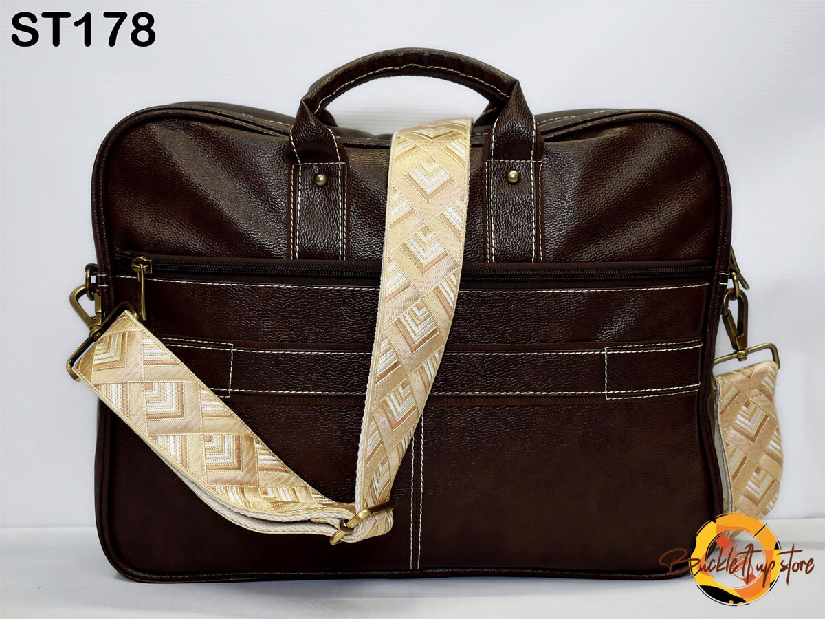 A brown leather briefcase bag with a patterned strap and multiple pockets.
