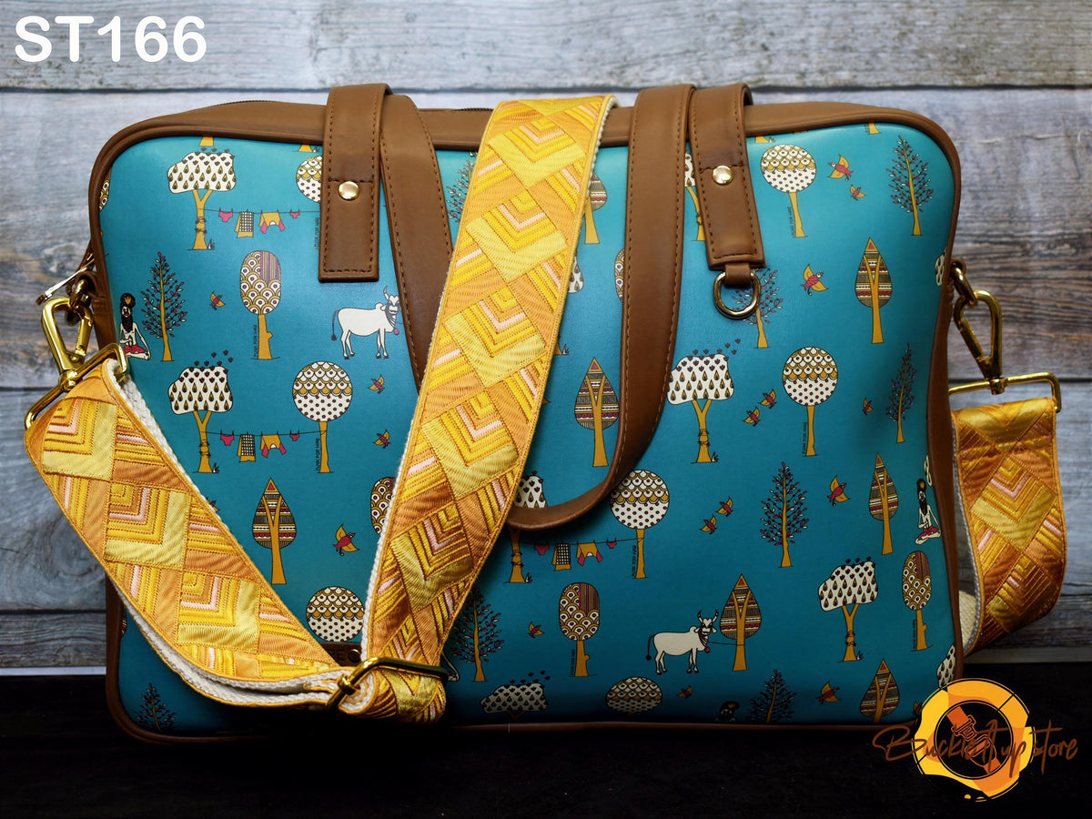 A colorful handbag with a pattern of trees, flowers, and other nature-inspired designs on a blue background.