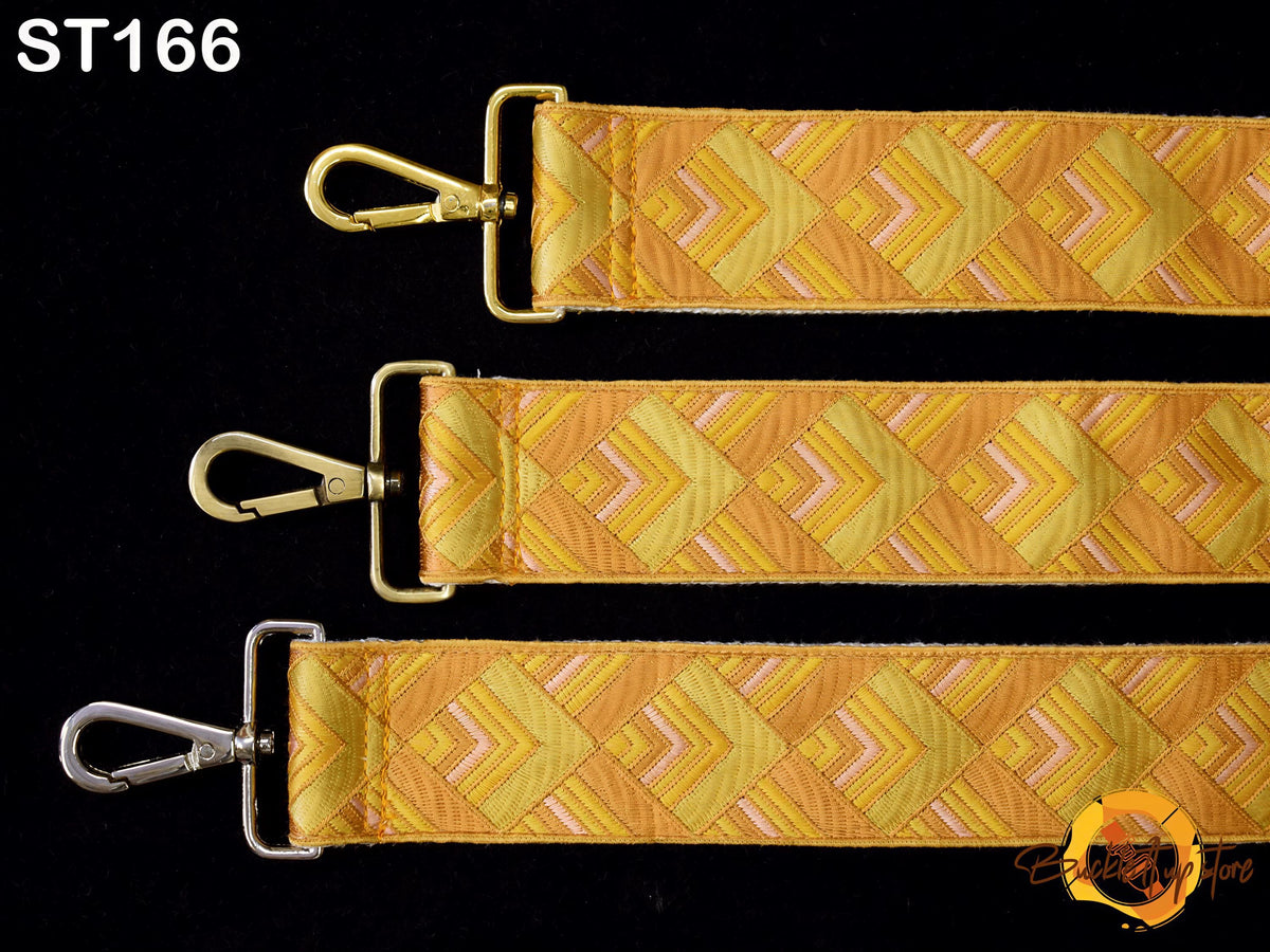 three straps with a geometric pattern in shades of yellow and orange, arranged in a row against a black background.