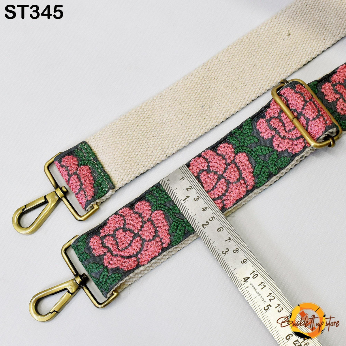 a strap with a floral pattern, and a ruler is placed next to it, indicating the strap's size.