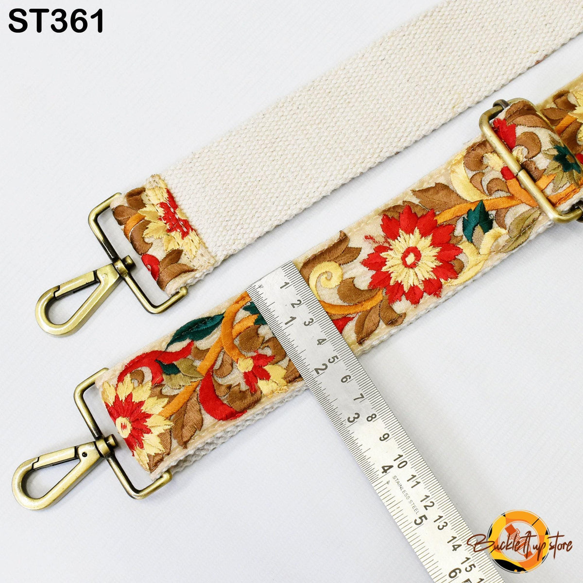 a strap with a floral pattern and a ruler placed next to it, indicating the strap's size.