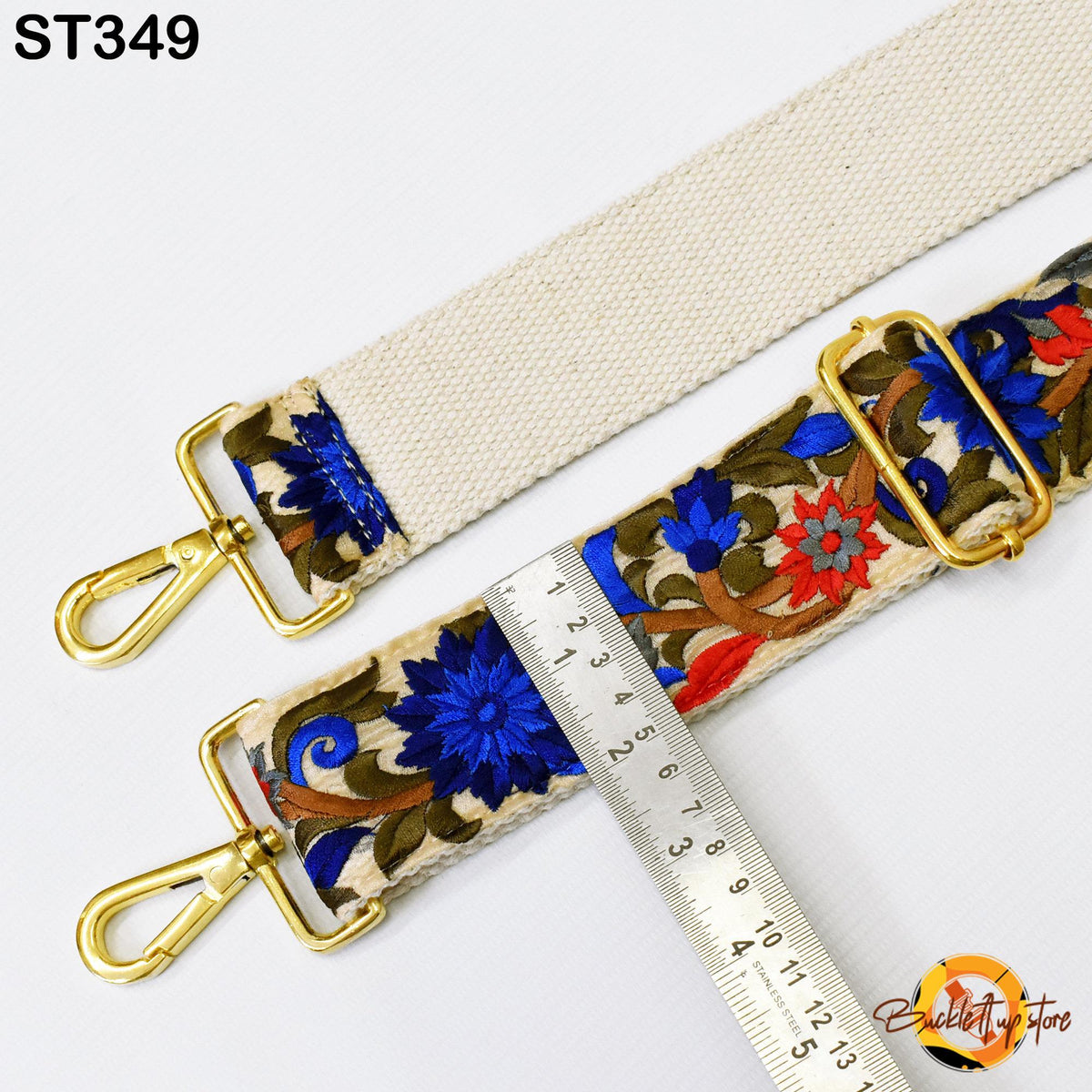 a strap with a floral pattern and a ruler placed next to it, indicating the strap's size.
