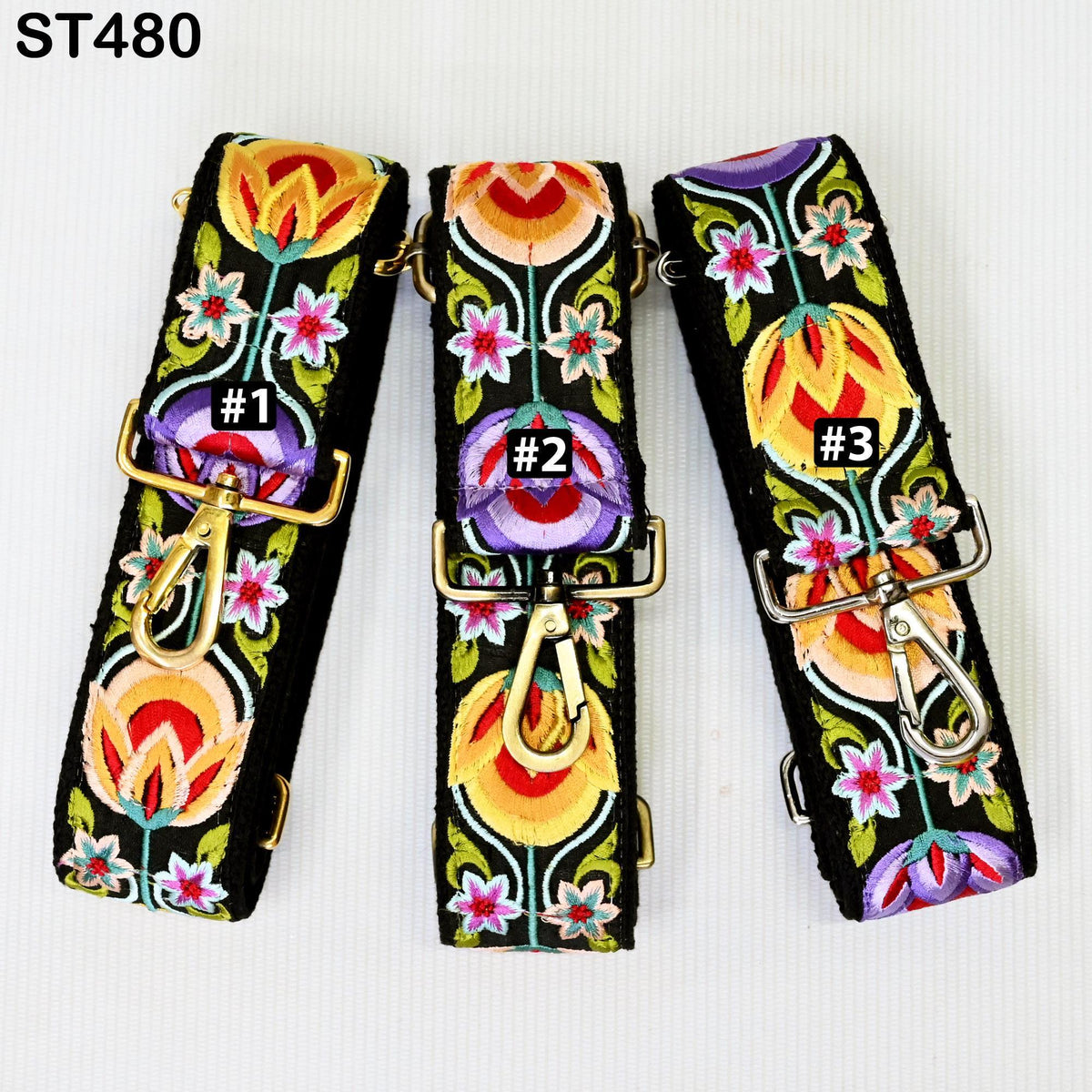 three colorful, floral-patterned straps with gold buckles, arranged side by side.