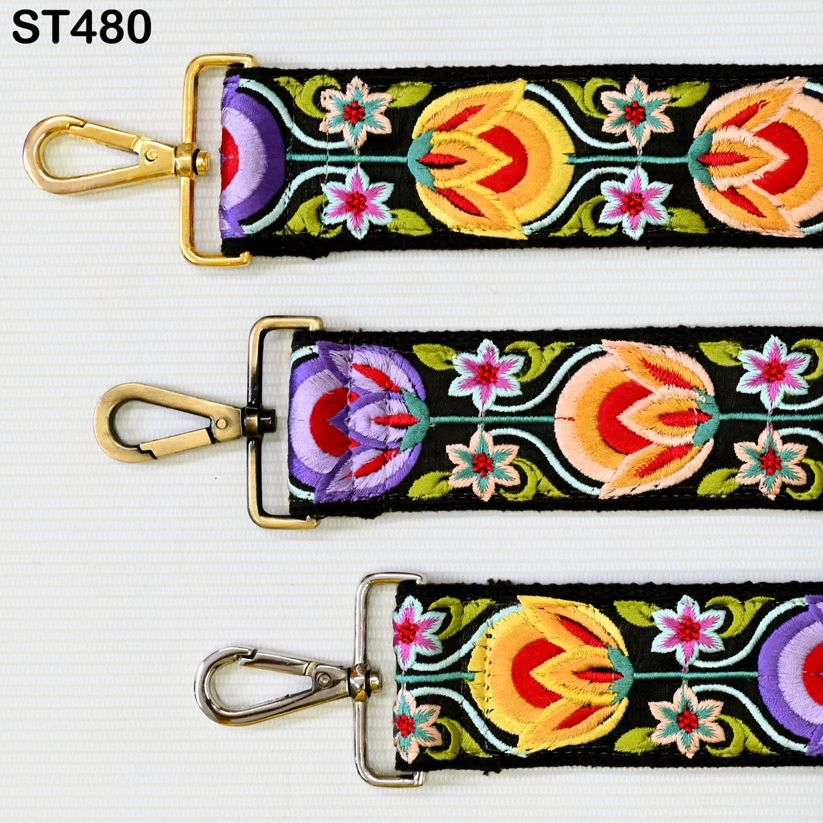 three colorful straps with floral patterns, each featuring a gold clasp and a metal loop.