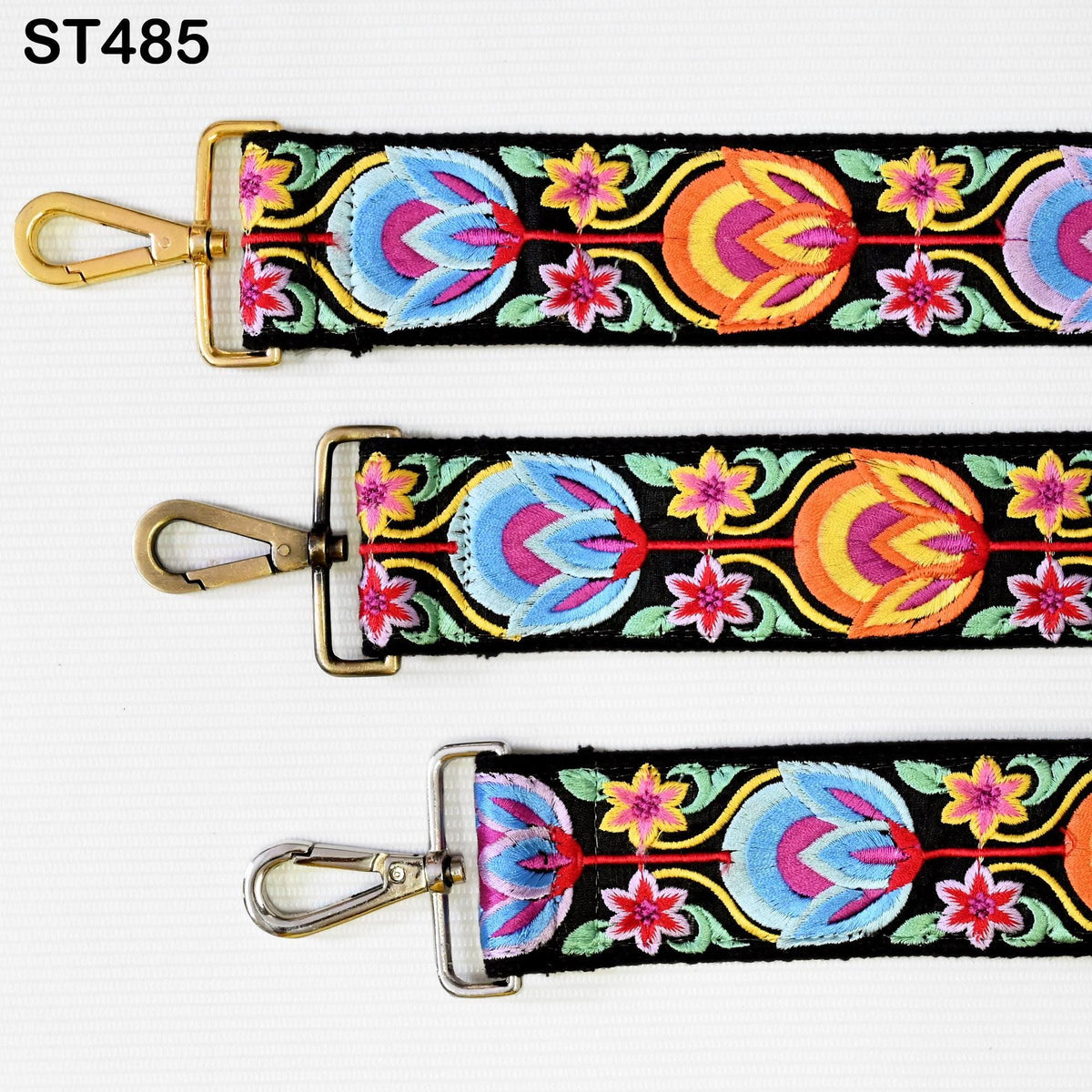 three colorful, embroidered straps with floral patterns. The straps appear to be made of fabric and have metal hooks or buckles attached to them.