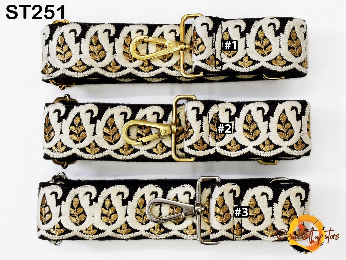three straps with a paisley pattern in black and white, each with a gold clasp and metal buckle.