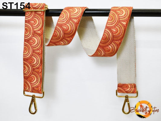 a colorful, patterned strap with a gold metal buckle attached to a black metal bar.