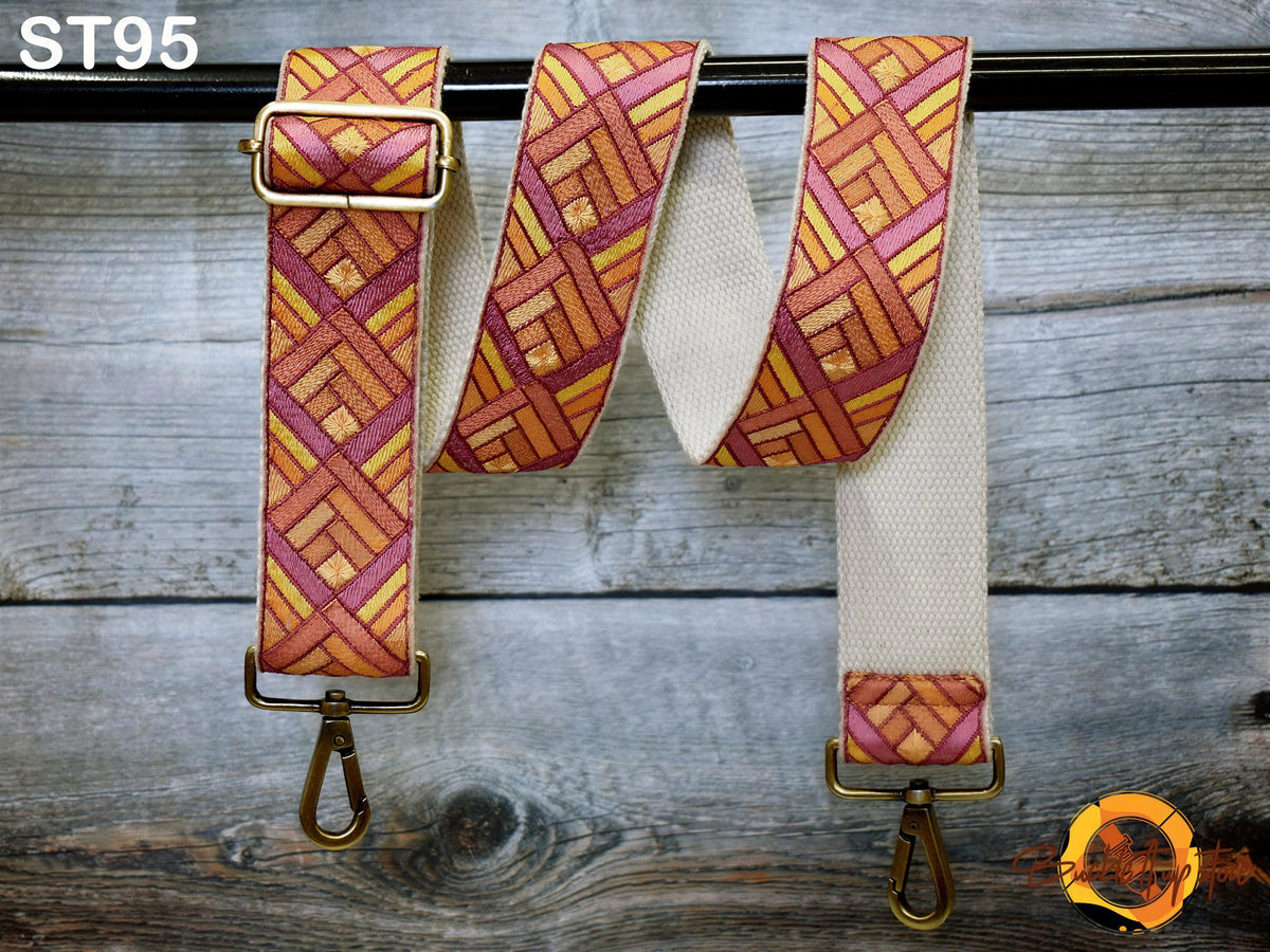 a colorful strap with a geometric pattern, hanging on a wooden surface.