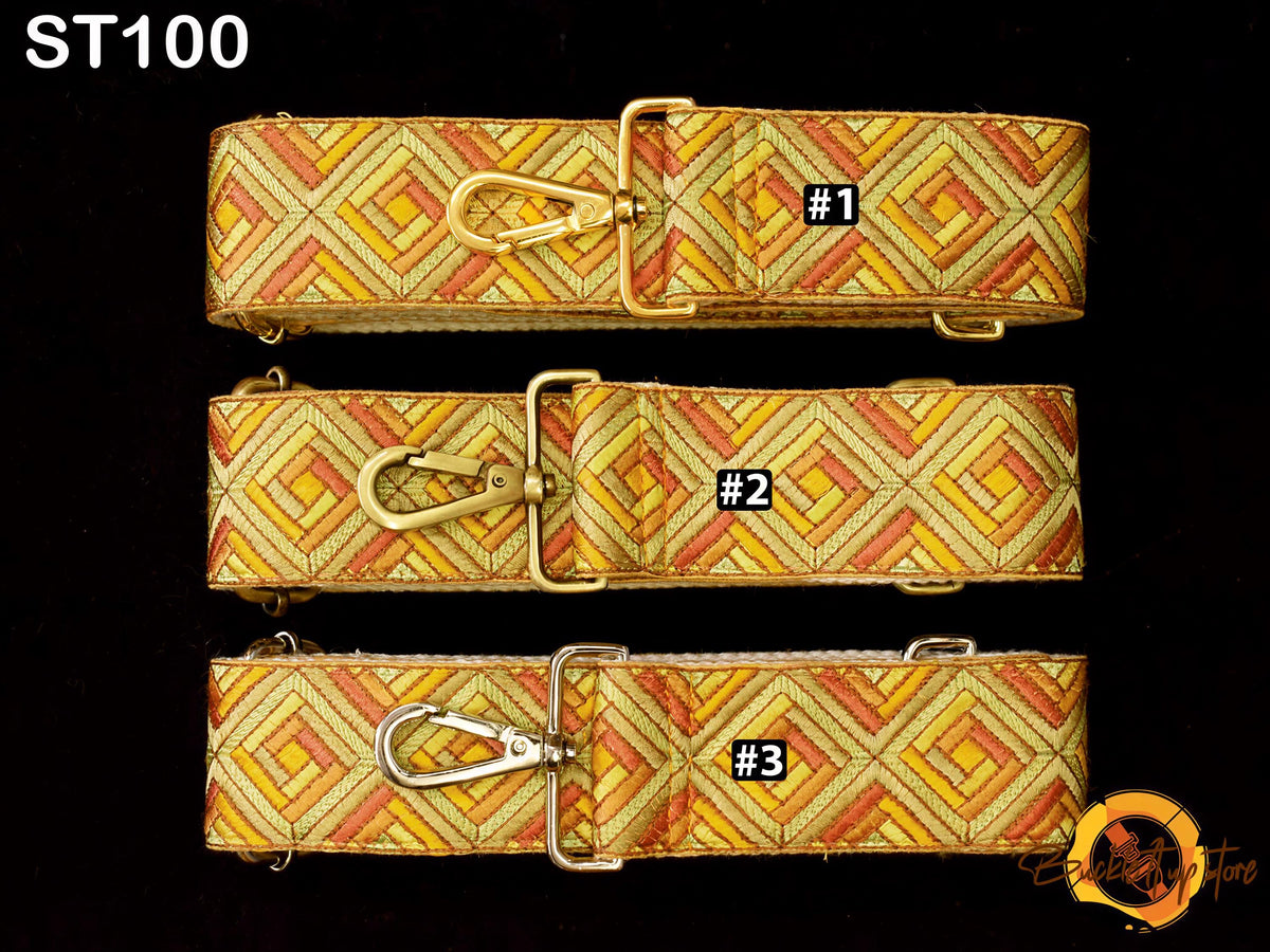 three straps with a geometric pattern in shades of yellow and orange, each with a metal clasp and a label indicating the strap number.