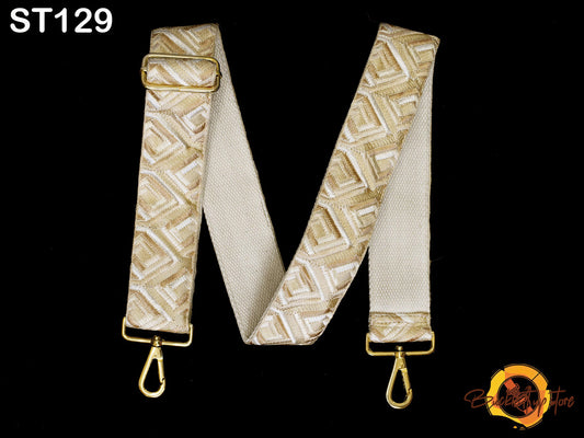 a beige strap with a geometric pattern, attached to a gold metal buckle.
