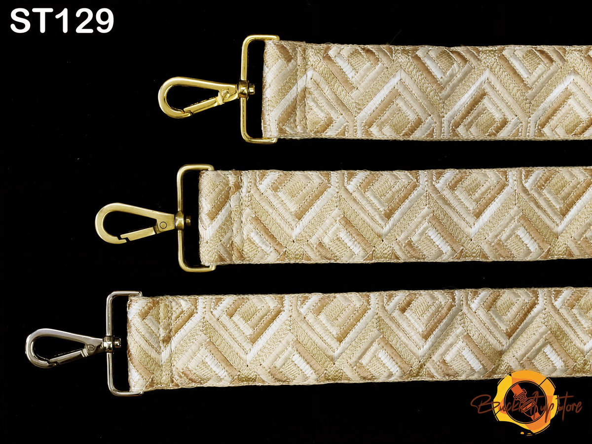 three straps with a geometric pattern in shades of beige and gold, arranged in a row against a black background.