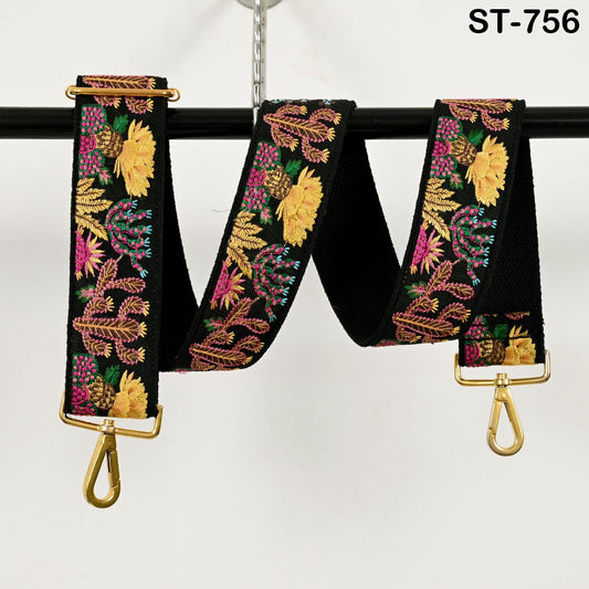 A colorful, floral-patterned strap with gold hardware, hanging from a black hook.