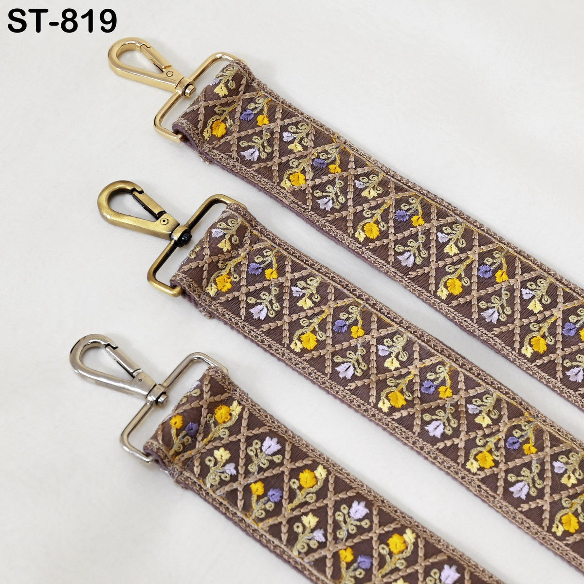 three brown straps with gold metal hooks and floral embroidery patterns.