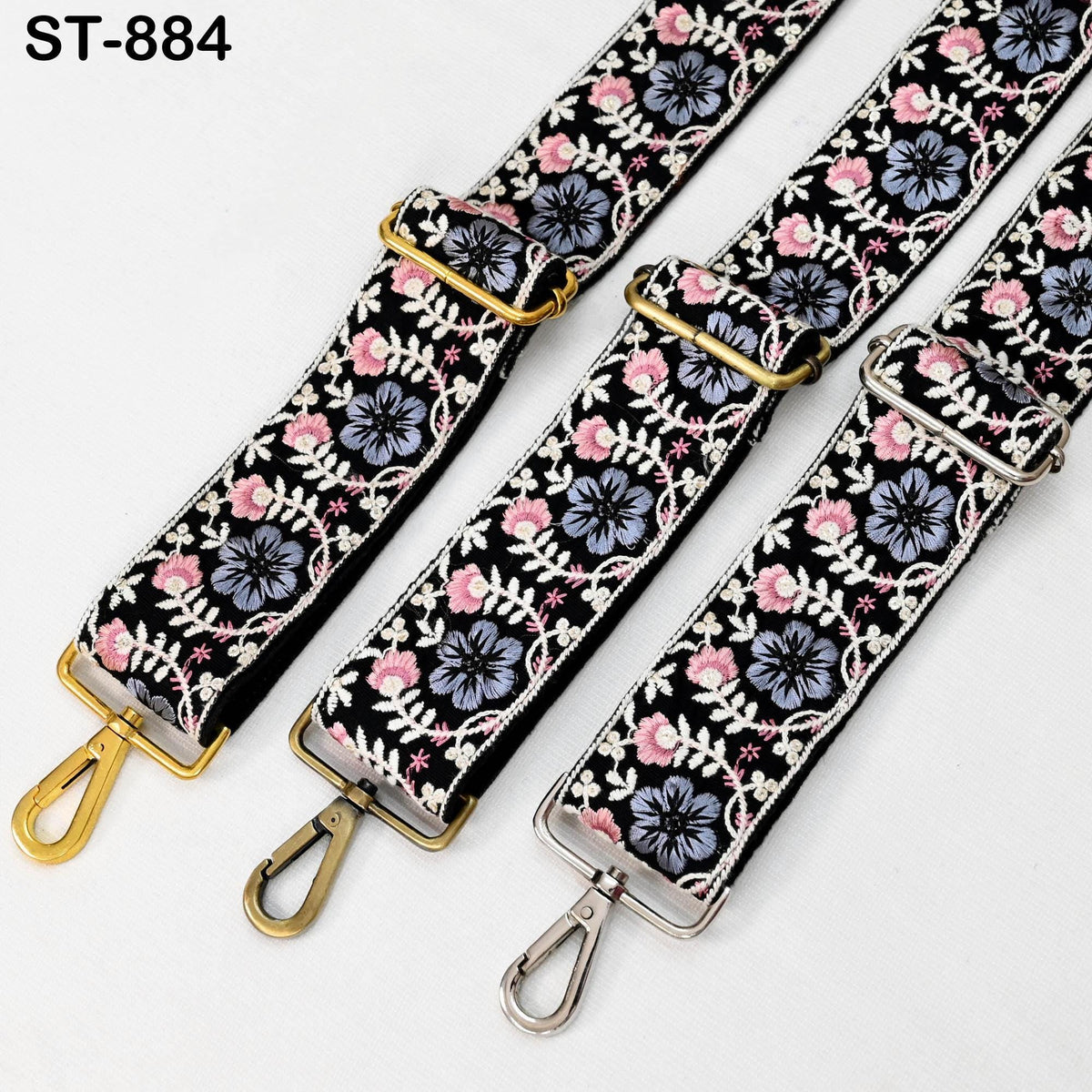 three straps with floral patterns in black, white, and pink colors. The straps appear to be made of fabric and have metal hardware, such as buckles and clips.
