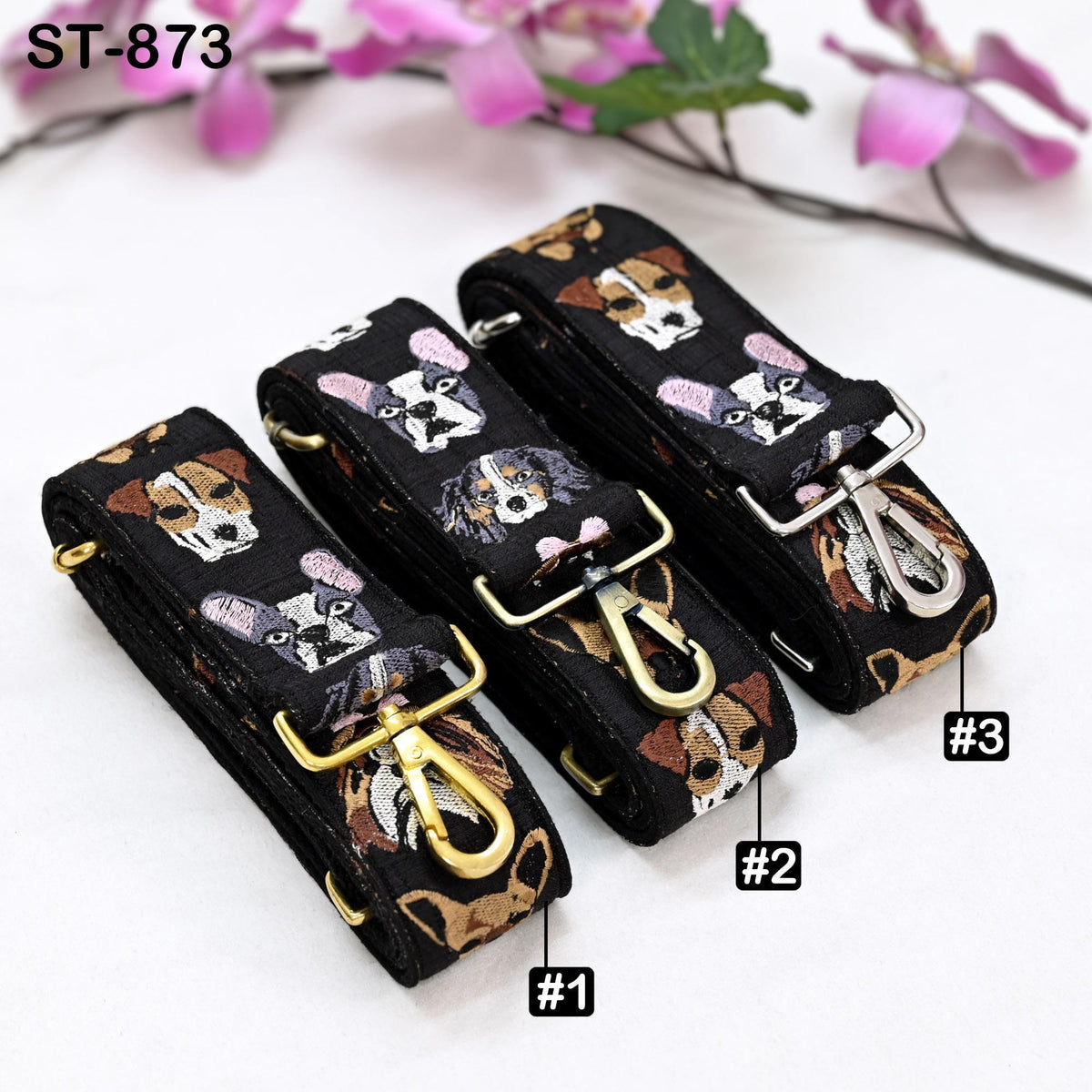 Three black straps with dog faces printed on them, each with a gold-colored metal buckle.