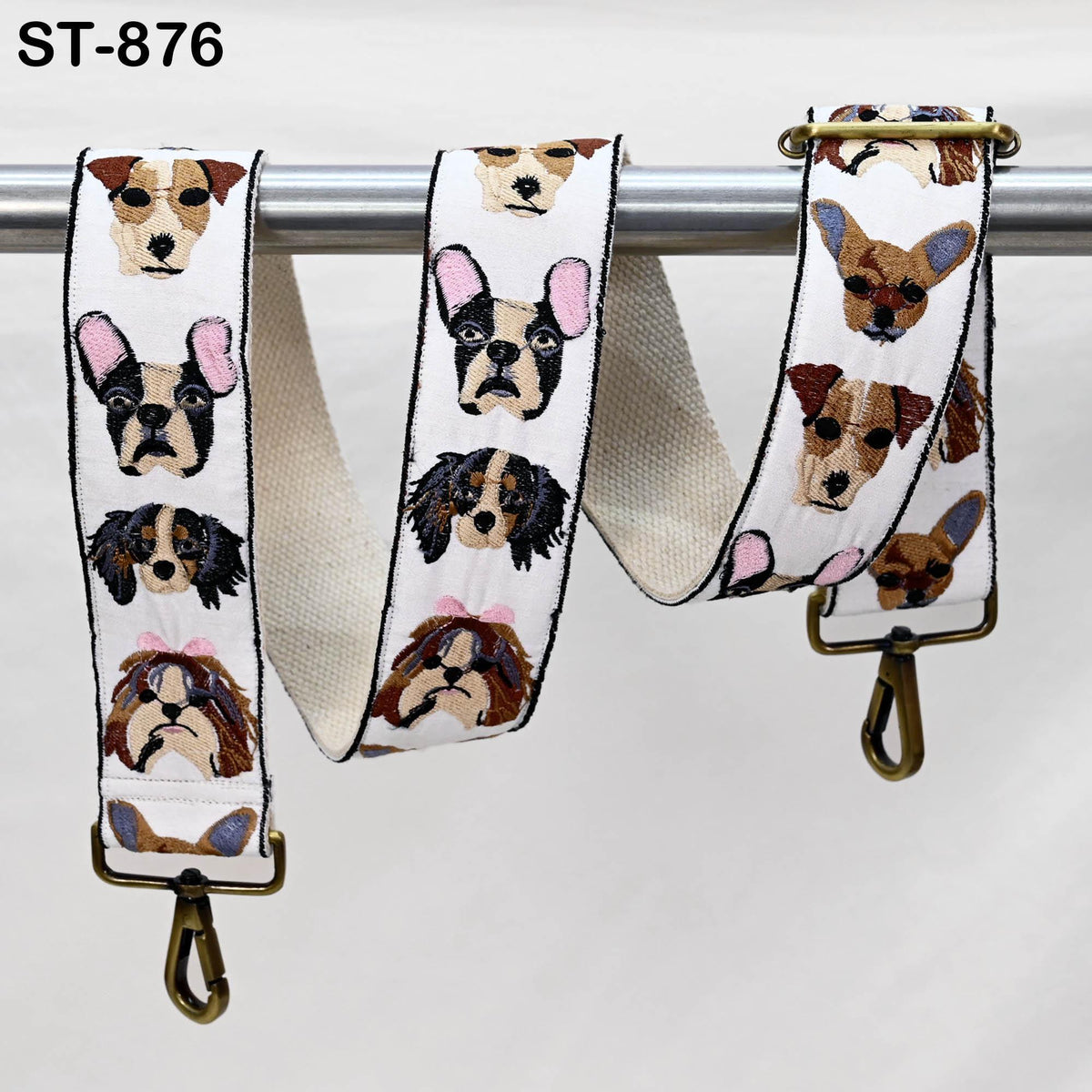 A strap with a repeating pattern of dog faces on it, hanging from a metal bar.
