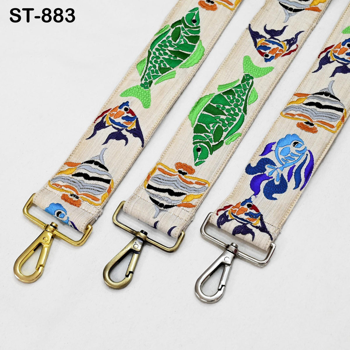 three colorful straps with fish designs, each with a metal clasp and hook.