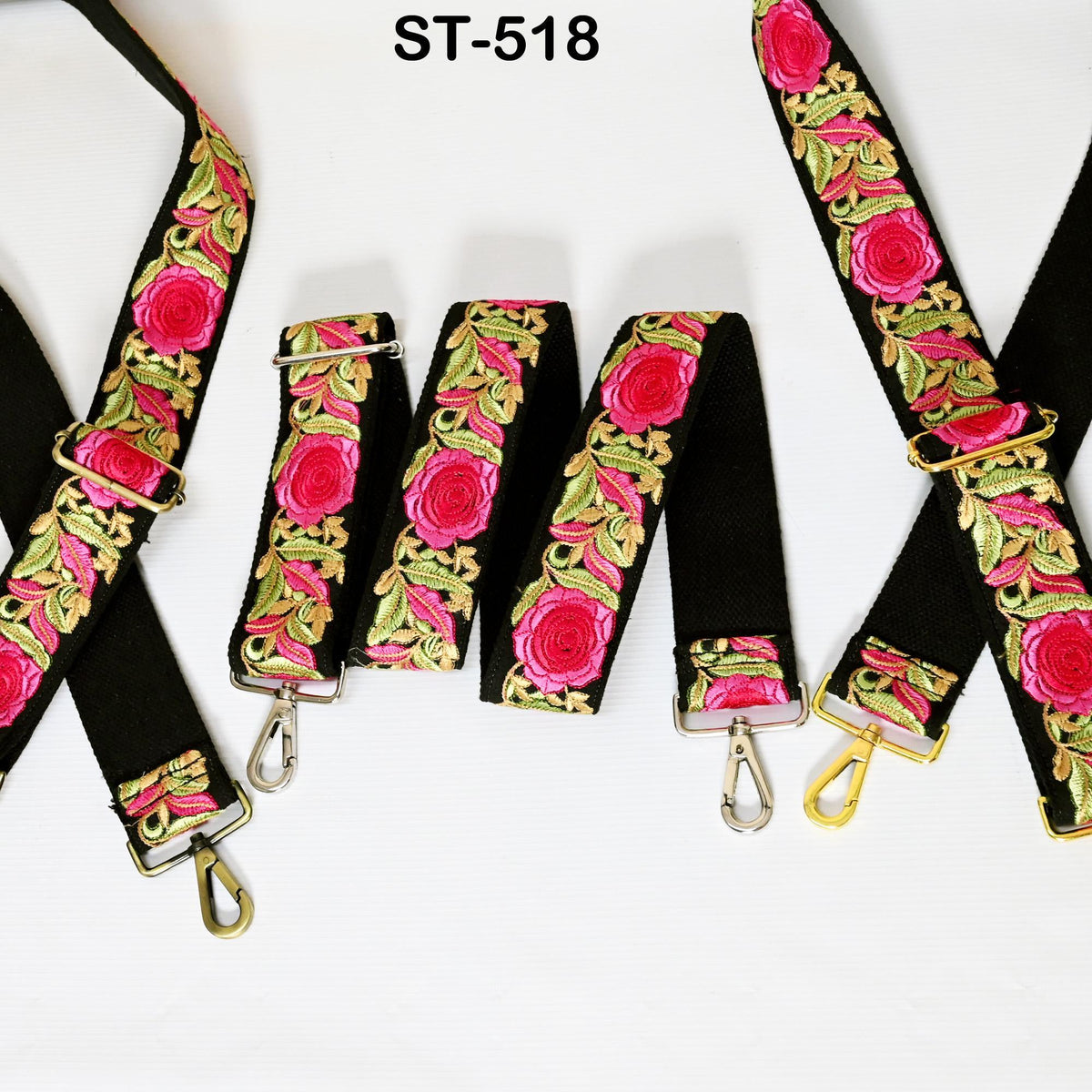 a collection of black straps with pink and green floral embroidery. The straps are arranged in a row, showcasing their intricate designs and vibrant colors.