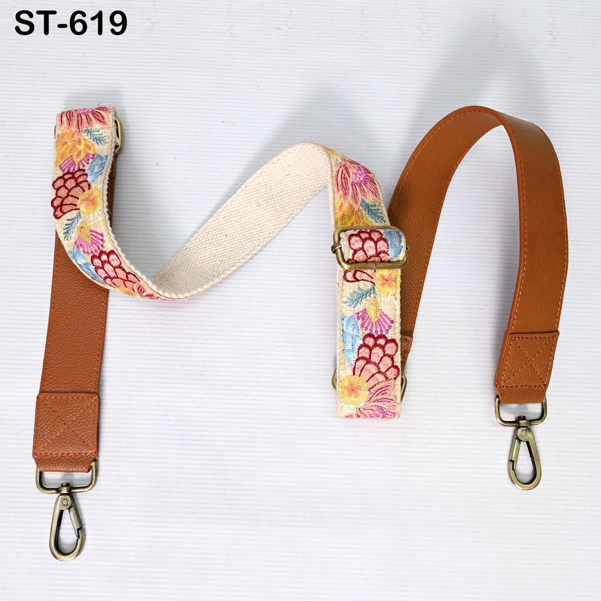 A floral-patterned strap with a leather strap attached, both of which are attached to a metal hook.