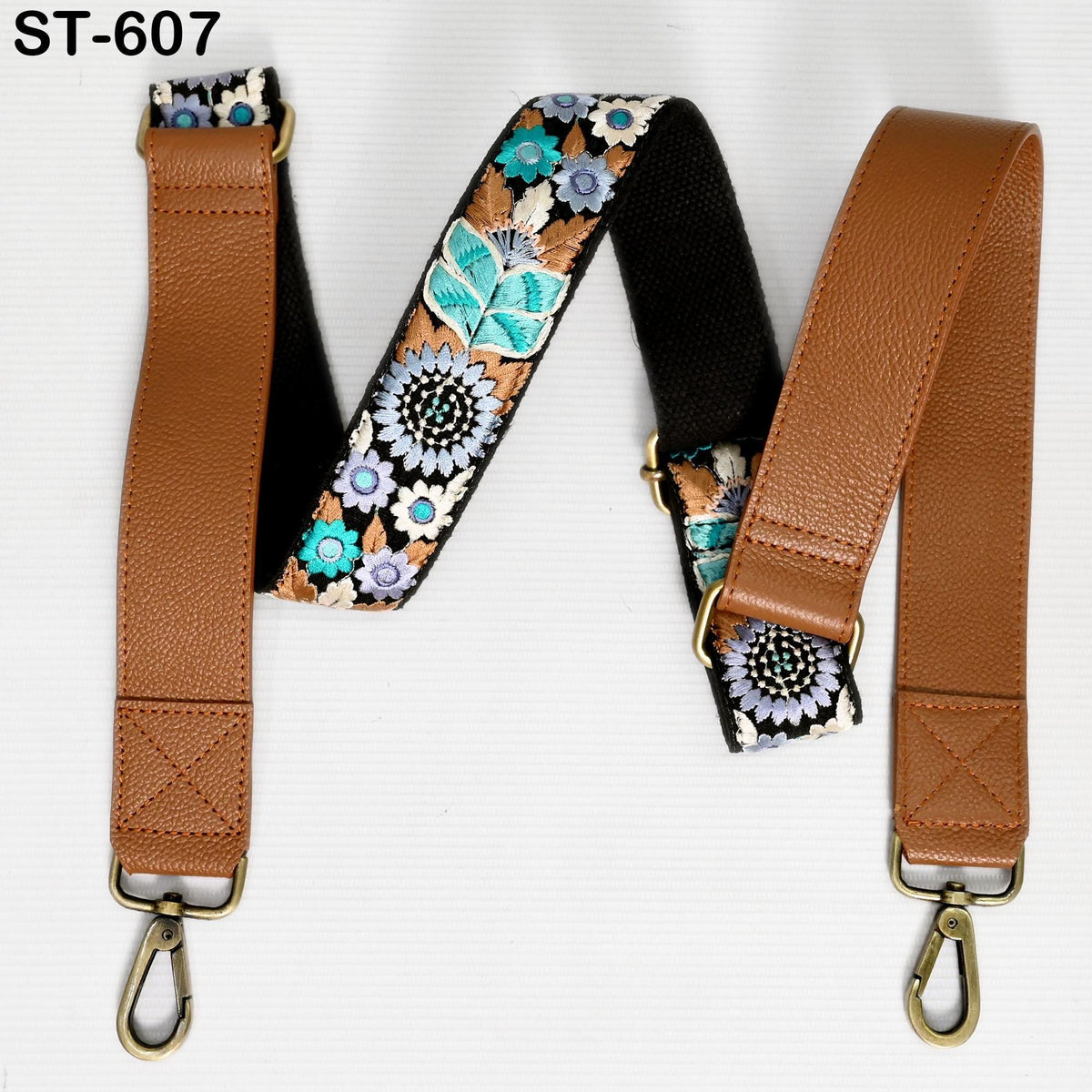 a brown leather strap with a floral pattern, featuring two metal hooks at the ends.