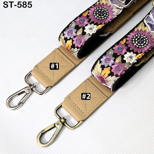 two straps with floral patterns, one with a beige color and the other with a black and white floral pattern. The straps have metal hooks and buckles, and there are small labels on them indicating the number 1 and 2.