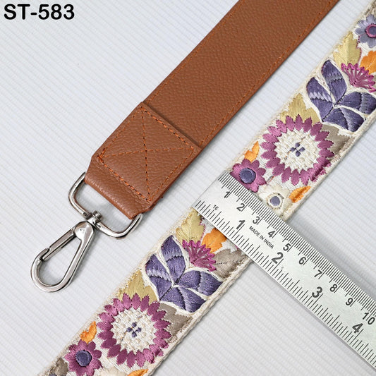 a brown leather strap with a floral pattern and a metal ruler placed next to it, indicating the strap's size.