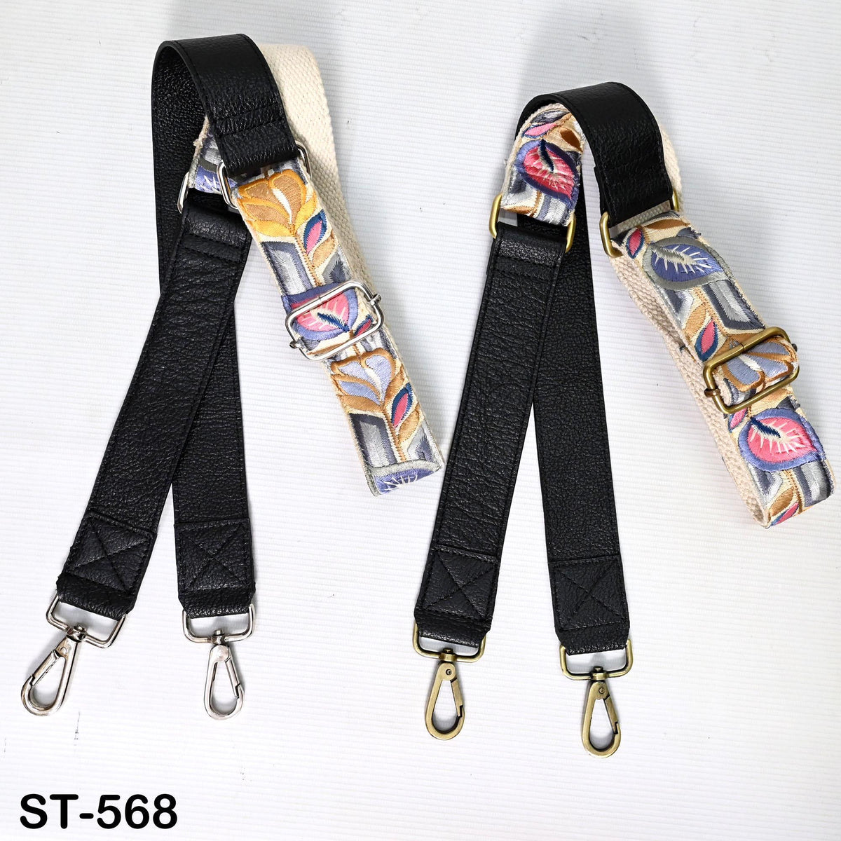 two black leather straps with metal hooks, each with a unique patterned design, placed on a white background.