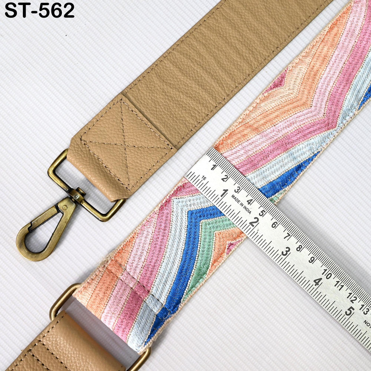 a beige strap with a colorful, striped pattern, and a ruler is placed next to it, indicating the strap's length.