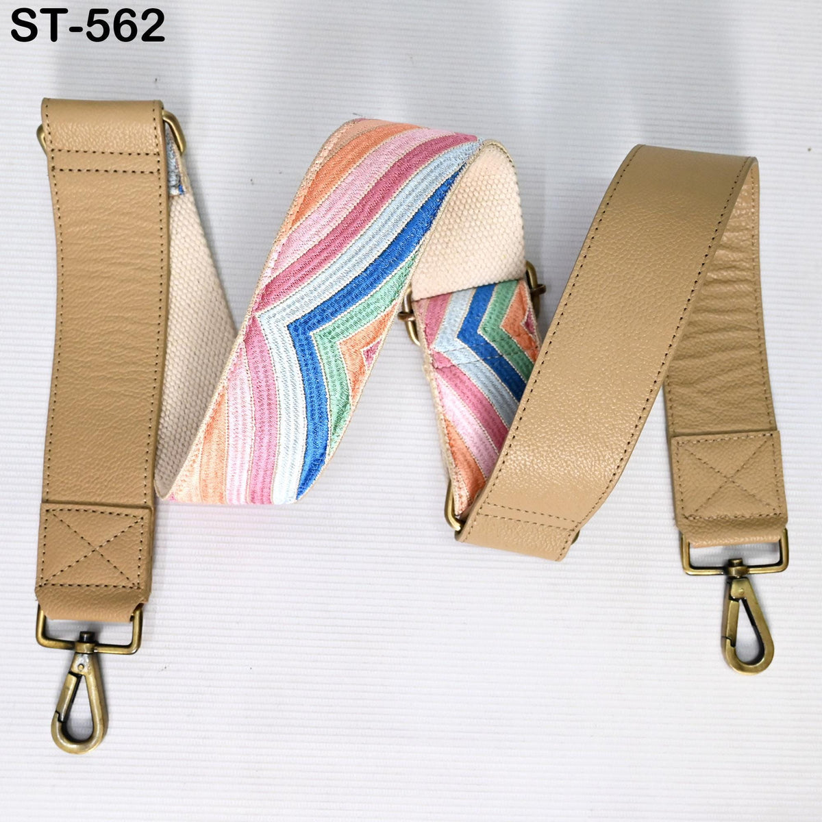a beige leather strap with a colorful, striped pattern on it. The strap appears to be a crossbody or shoulder strap, and it is attached to a metal hook or clasp.